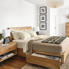 a bed sitting in a bedroom next to a wooden dresser under a white light fixture