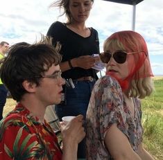 two people sitting next to each other at an outdoor event