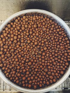 a large bowl filled with lots of brown balls on top of a metal grate