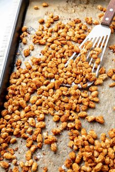 a pan filled with fried peanuts and a spatula