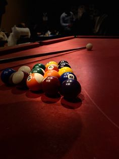 several pool balls lined up in a row on a red carpeted area with people watching