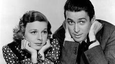 a man and woman are posing for a photo in front of a white background with polka dots