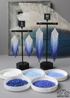 three bowls with beads hanging from them in front of a mirror and sign that says m s