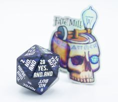 a black and white dice sitting on top of a table next to a sticker