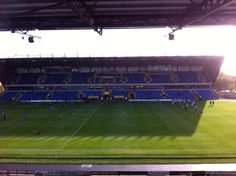 a soccer field with players on it and the sun shining through the roof over them