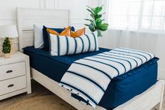 a bed with blue and white striped pillows on it