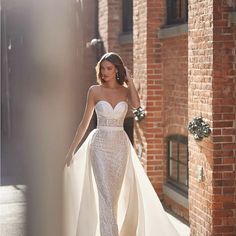 a woman in a wedding dress walking down the street