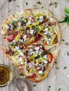 two pizzas with different toppings are on a cutting board