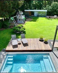 an above ground pool surrounded by grass and wooden decking with lounge chairs on it