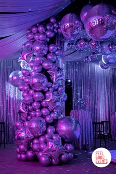 purple balloons are hanging from the ceiling at a party