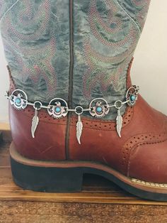 Beautiful hand crafted Concho boot jewelry. These are faux  silver small thunderbirds with man made turquoise stones in center. Faux silver feathers dangle in between the 3/4" Conchos. This boot bracelet  has Lobster clasp.   This is a Unique style not to be found anywhere but Old hands Creations! These are 15.5" total length Please check out our other items as some are complimentary to this item. If you buy 2 or more items you will get 15% off! Spend $50 and get 20% off. We can ship multiple it Rodeo Jewelry, Boot Bracelet, Cowgirl Rodeo, Cowboy Christmas, Boot Jewelry, Old Hands, Western Boot, Silver Feather, Cow Girl