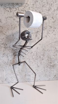 a toilet paper holder with a skeleton holding a roll of toilet paper in it's arms