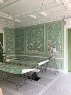 an empty room with green wallpaper and white paint on the walls is being worked on