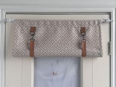 a window with two straps hanging from it's side and the curtain is closed