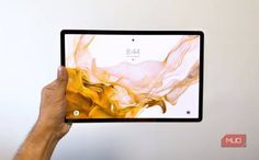 a person holding up an ipad with the screen showing liquid flowing down it's side