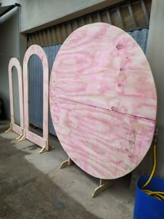 two large round wooden boards sitting next to each other in front of a garage door