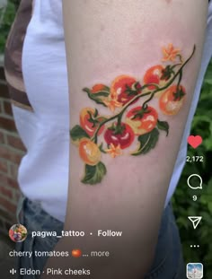 a woman's arm with an orange and red flower tattoo on the left side of her arm