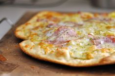 a pizza sitting on top of a wooden cutting board