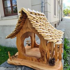 a small wooden house made out of wood with a roof that has circles on it