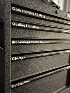 five metal drawers with labels on them sitting next to each other