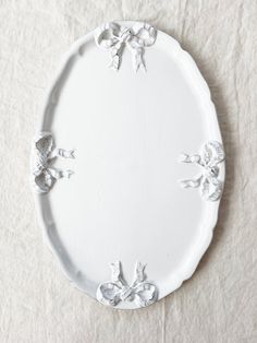 a white plate with flowers on it sitting on a cloth covered tableclothed surface