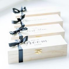 three wooden boxes with black ribbons tied around them