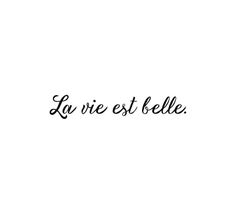 the word la vie est belle written in black ink on a white background