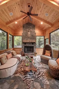 a living room filled with furniture and a fire place in the middle of an open floor plan