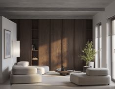 a living room filled with white furniture and wooden paneling on the wall behind it