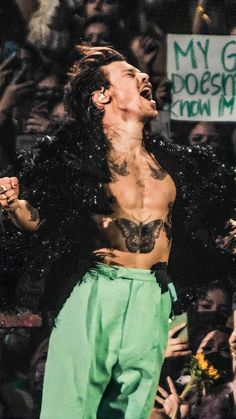 a man with long hair standing in front of a crowd