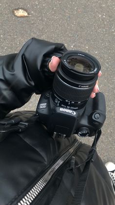 a person taking a photo with a camera on the street in front of their jacket