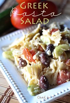 pasta salad with olives and tomatoes on a white plate