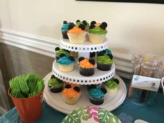 a three tiered cake with cupcakes on it