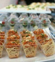 there are many different types of food in plastic cups on the trays that have been placed together