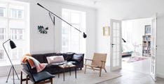 a living room filled with furniture and lots of windows next to a book shelf full of books