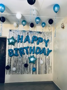 a room with balloons and streamers that say happy birthday