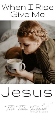 a woman holding a coffee mug while laying on top of a bed with the words jesus written