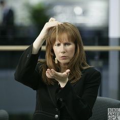 a woman in black jacket holding her head with both hands and looking at the camera