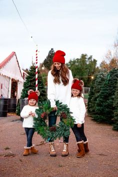 a woman and two children holding a christmas wreath