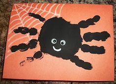 a handprinted spider on an orange background with black hands and webs in the center