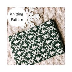 the knitting pattern is knitted in green, white and black with snowflakes on it