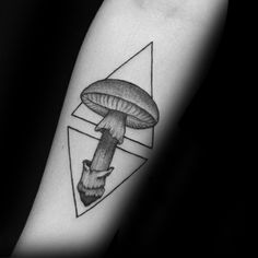 a black and white photo of a mushroom tattoo on the left inner arm with an inverted triangle behind it