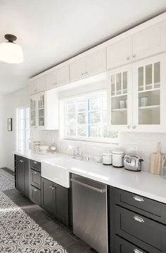 a kitchen with white cabinets and black drawers