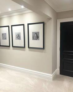 three black and white pictures hang on the wall in an empty room with beige carpet