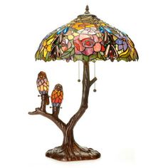 a lamp that is sitting on top of a tree with two birds perched on it