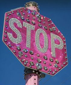 a pink stop sign with lots of rivets on it