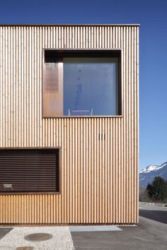 the side of a wooden building with windows and shutters on it's sides