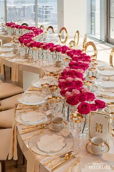 the table is set with pink roses and gold place settings for an elegant wedding reception