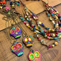 several colorful necklaces are displayed on a wooden table with beads and charms hanging from them