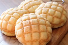 four sugar cookies sitting on top of a wooden cutting board